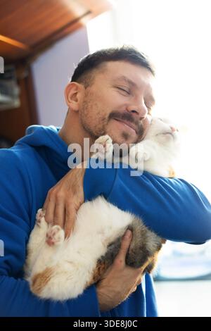 Uomo con gatto carino. Animali domestici e umani amicizia, amore e fiducia Foto Stock