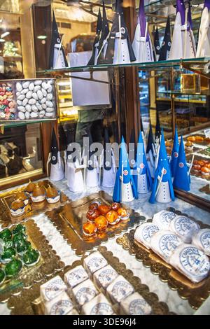 Il negozio di caramelle la Campana di Siviglia espone nella vetrina dolci della settimana Santa a forma di penitenti. Affascinanti dolci culturali, Spagna. Foto Stock