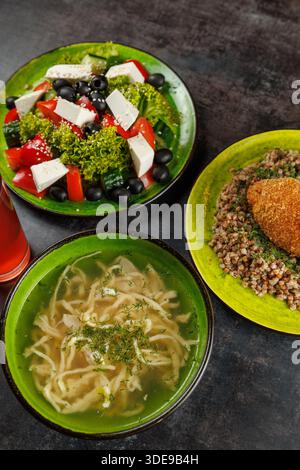 Insalate fresche, ricche zuppe e saporiti piatti a base di cereali disposti su piatti vivaci mostrano la diversità della cucina Ucraina e giapponese in un ristorante Foto Stock