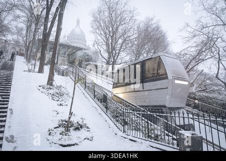 La funicolare di Montmartre è visibile durante la tempesta di neve che ha colpito Parigi. Una forte tempesta di neve ha colpito la capitale francese, causando molta eccitazione tra parigini e turisti , ma anche un sacco di disagi nei trasporti su strada. Vicino alla Basilica del Sacro cuore nel quartiere di Montmartre, la gente scivola giù dalla collina sulla neve. Foto Stock