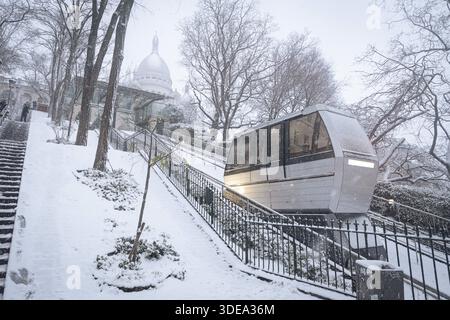 Parigi, Francia. 5 gennaio 2026. La funicolare di Montmartre è visibile durante la tempesta di neve che ha colpito Parigi. Una forte tempesta di neve ha colpito la capitale francese, causando molta eccitazione tra parigini e turisti, ma anche molti disagi nei trasporti su strada. Vicino alla Basilica del Sacro cuore nel quartiere di Montmartre, la gente scivola giù dalla collina sulla neve. (Immagine di credito: © Telmo Pinto/SOPA Images via ZUMA Press Wire) SOLO PER USO EDITORIALE! Non per USO commerciale! Foto Stock