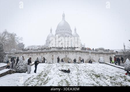 Parigi, Francia. 5 gennaio 2026. Vicino alla basilica del Sacro cuore di Montmartre si vedono persone durante la tempesta di neve che ha colpito Parigi. Una forte tempesta di neve ha colpito la capitale francese, causando molta eccitazione tra parigini e turisti, ma anche molti disagi nei trasporti su strada. Vicino alla Basilica del Sacro cuore nel quartiere di Montmartre, la gente scivola giù dalla collina sulla neve. (Immagine di credito: © Telmo Pinto/SOPA Images via ZUMA Press Wire) SOLO PER USO EDITORIALE! Non per USO commerciale! Foto Stock