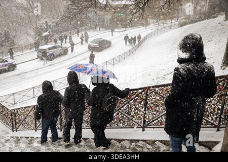 Parigi, Francia. 5 gennaio 2026. Vicino alla basilica del Sacro cuore di Montmartre si vedono persone durante la tempesta di neve che ha colpito Parigi. Una forte tempesta di neve ha colpito la capitale francese, causando molta eccitazione tra parigini e turisti, ma anche molti disagi nei trasporti su strada. Vicino alla Basilica del Sacro cuore nel quartiere di Montmartre, la gente scivola giù dalla collina sulla neve. (Immagine di credito: © Telmo Pinto/SOPA Images via ZUMA Press Wire) SOLO PER USO EDITORIALE! Non per USO commerciale! Foto Stock