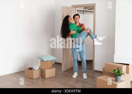 La coppia Millennial celebra con gioia il Moving Day nel loro nuovo appartamento Foto Stock