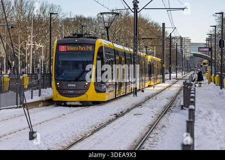 Vista laterale di un moderno tram elettrico giallo e grigio in attesa presso una stazione di Utrecht con neve che copre i binari, la piattaforma e i dintorni. Utrecht Foto Stock