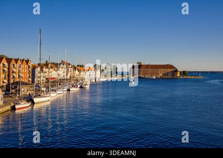 Skyline con cielo blu e luce solare serale nella città danese di Sonderborg, affacciata sul lungomare con barche a vela e castello Foto Stock