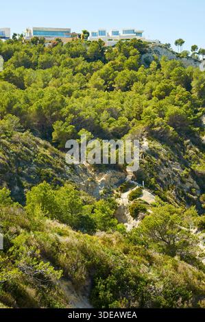 Ville di lusso sulle scogliere con un sentiero tra la pineta appena sopra la spiaggia di Cala Sardinera (Portichol, Jávea, Marina alta, Alicante, Spagna) Foto Stock
