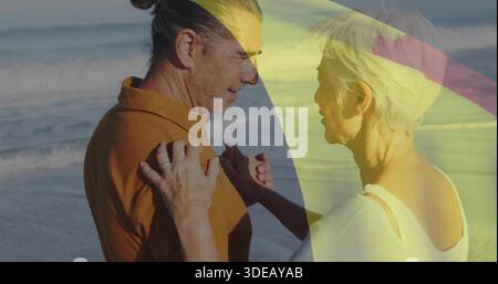 Avvolgente camicia marrone uomo coppia dai capelli grigi top donna bianco sul litorale con anelli fasce ombrello Foto Stock