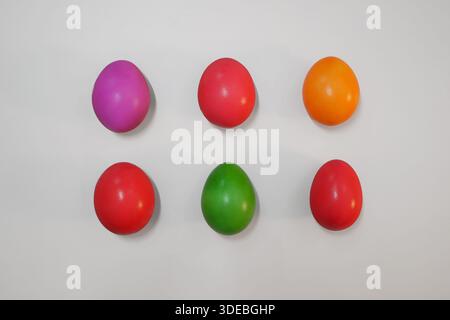 Deposizione piatta minima di uova di Pasqua colorate disposte in una griglia su sfondo bianco. Concetto di vacanza di primavera per la festa di Pasqua, la decorazione, il saluto c Foto Stock