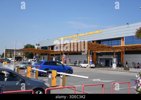 Viaggiate nell'edificio del terminal dell'aeroporto transilvania targu mures della romania con le auto in arrivo e in partenza all'ingresso Foto Stock
