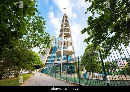 Campanile della Cattedrale metropolitana di Rio de Janeiro con Croce in cima circondata da alberi Foto Stock