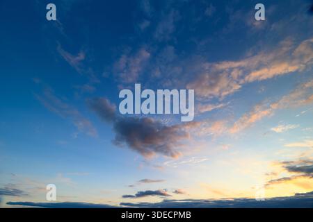 La vista mozzafiato di uno splendido cielo al tramonto mostra una gamma di colori vivaci e soffici nuvole Foto Stock