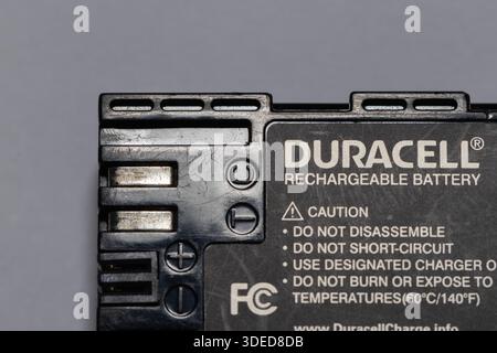 Batteria ricaricabile duracell che offre alimentazione elettrica per vari dispositivi su sfondo grigio Foto Stock