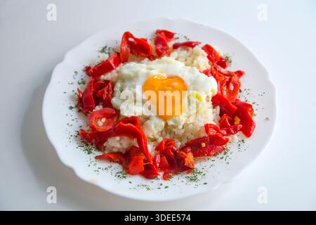 Dieta mediterranea: riso con peperoni rossi e uovo fritto. Foto Stock