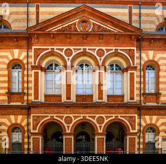Facciata dell'edificio decorata con finestre ad arco e motivi decorativi. Foto Stock