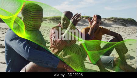 Tre uomini seduti a chiacchierare sulla spiaggia di sabbia con abiti casual con giacca in denim e rete verde neon Foto Stock