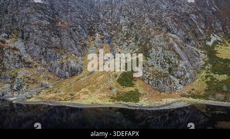 Vista aerea di Llyn Eigiau con ripidi pendii rocciosi che si riflettono nell'acqua ferma Foto Stock
