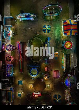 Vista aerea di una zona fieristica illuminata da colori vivaci e giostre emozionanti sotto il cielo notturno, Nassau, Bahamas. Foto Stock