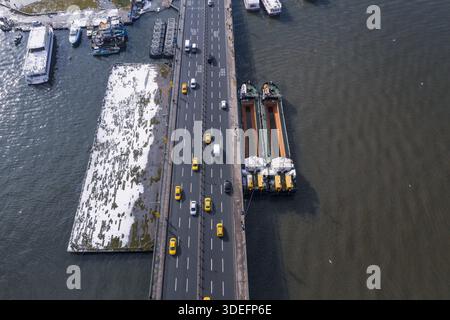 Vista aerea del ponte Galata, pieno di traffico, in contrasto con le acque scure circostanti e le barche attraccate, Istanbul, İstanbul, Turkiye. Foto Stock