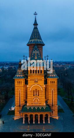 Vista aerea della cattedrale ortodossa di Timișoara inondata di luce calda contro il fresco crepuscolo, un faro maestoso nel paesaggio urbano, Timișoara, T. Foto Stock