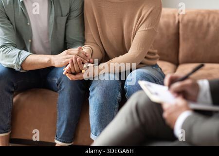 Coppia che parla alla sessione con il terapeuta maschile Foto Stock
