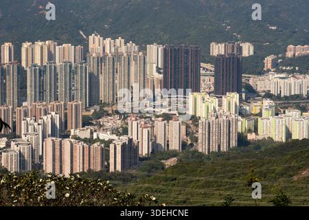 Edifici residenziali a Hong Kong, accoccolati su lussureggianti colline verdi. Foto Stock