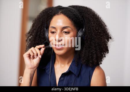 Amichevole agente di assistenza clienti con cuffia in camicia blu che fornisce assistenza virtuale online oggi stesso Foto Stock