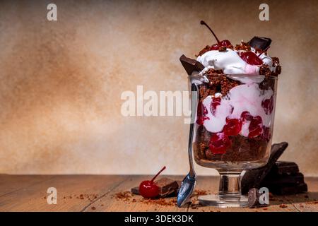 Trifle di torta di brownie, dessert a strati di foresta nera con biscotto di spugna al cioccolato, panna montata, rum e ciliegie dolci e gustose Foto Stock