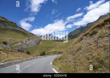 Un'ampia vista panoramica a nord mostra la tortuosa strada del passo D934, che si snoda attraverso i ripidi pendii erbosi e le aspre formazioni rocciose Foto Stock