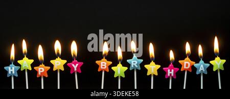 Candele che bruciano con le parole buon compleanno, candele che bruciano a lunga fila, isolate su sfondo nero scuro. Concetto di progettazione di carte Happy Birthday Foto Stock