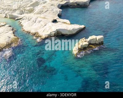 La vista aerea delle scogliere bianche e aspre incontra le acque turchesi, creando un contrasto mozzafiato in questo paradiso costiero, Milos, Anatoliki Attiki, G. Foto Stock