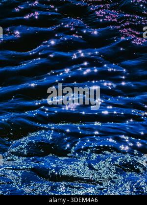 Superficie oceanica astratta con riflessi solari simili a diamanti – sfondo calmo blu per un'estetica di sfondo verticale di design premium Foto Stock