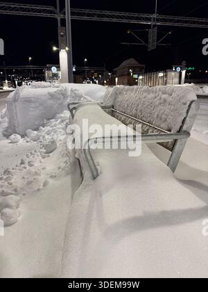 Panchina coperta di neve alla stazione centrale di Uppsala, Uppsala, Svezia. Foto Stock