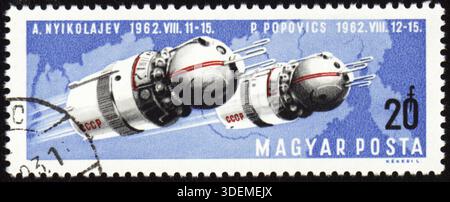 UNGHERIA - 1962 CIRCA: Un francobollo stampato in Ungheria mostra le astronavi sovietiche Vostok-3 e Vostok-4 con i cosmonauti Nikolaev e Popovich nello spazio, circa 1 Foto Stock