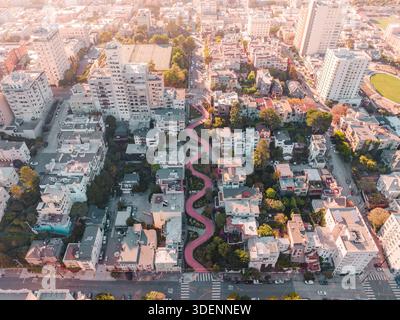 Veduta aerea della tortuosa strada di mattoni rossi di Lombard Street che attraversa un quartiere tra il paesaggio urbano di San Francisco, California, United St Foto Stock