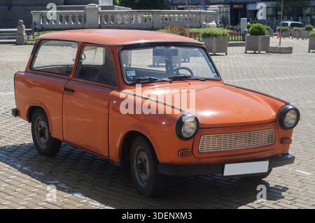 Auto Trabant restaurata in color arancio su strada lastricata Foto Stock