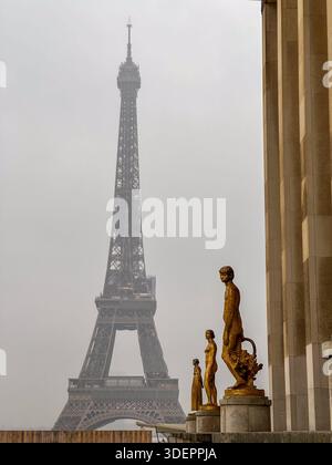 Statue dorate con colonne fanno da cornice alla lontana Torre Eiffel da Place du Trocadéro, Parigi. Foto Stock