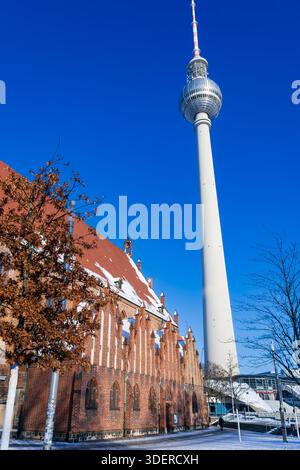 Fotografia verticale di Berlino che mostra l'iconica torre della televisione (Fernsehturm) che sovrasta la storica chiesa di Santa Maria (Marienkirche). Foto Stock