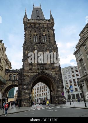 Porta d'ingresso della Powder Tower Archway circondata da edifici moderni e storici sulla trafficata strada di Praga, Repubblica Ceca. Foto Stock