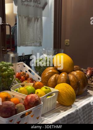 Primo piano di frutta colorata come uva, arance, meloni e mele su un bancone in un mercato alimentare romano. Foto Stock