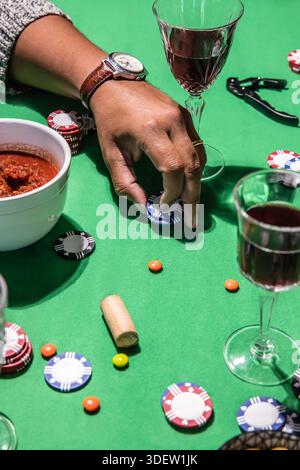 Posizionare a mano le patatine del poker sul tavolo verde Foto Stock