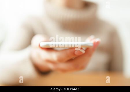 Donna che tiene lo smartphone, primo piano, messa a fuoco selettiva Foto Stock