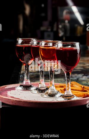 Quattro diverse bevande sono disposte su un piatto, offrendo un'esperienza di degustazione colorata e organizzata. Foto Stock