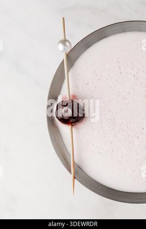Primo piano di un elegante martini lychee in un classico bicchiere martini, decorato con un litchi fresco, che mette in risalto il cocktail chiaro e la delicata consistenza Foto Stock