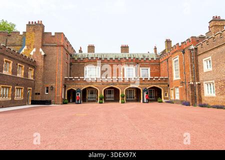 Vista del cortile interno di St James's Palace, che mostra la storica architettura in mattoni e le guardie reali britanniche in servizio. Foto Stock