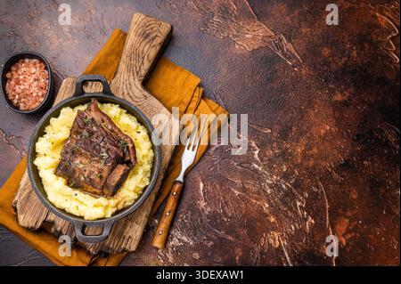 Primo piano di teneri costolette di manzo, splendidamente caramellate e riposate su un letto di cremoso purè di patate, creando un'invitante scena culinaria. marrone Foto Stock