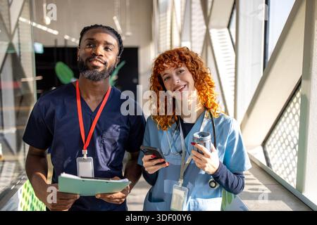 Pieno di giovani studenti che comunicano mentre camminano attraverso l'università medica Foto Stock