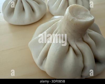 gnocchi di khinkali crudi su una superficie di legno con concetto di spazio testuale di ristorante e cibo Foto Stock