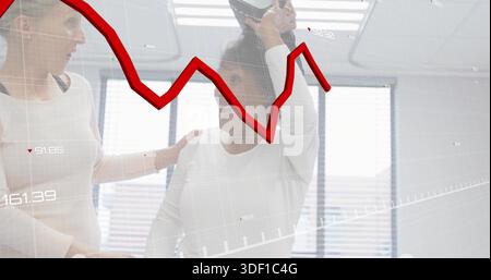 In piedi due donne che sostengono le finestre dell'ufficio e indossano maniche lunghe leggere con rivestimento grafico rosso Foto Stock