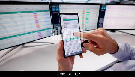 Contabile legale maschile che utilizza lo smartphone per calcolare le fatture finanziarie online Foto Stock